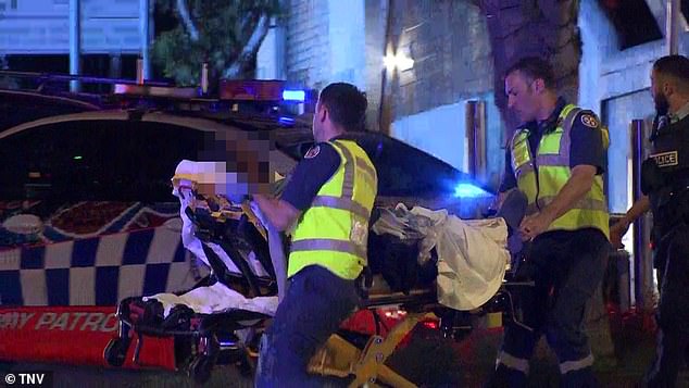 Paramedics are pictured attending to an individual in a stretcher at the scene
