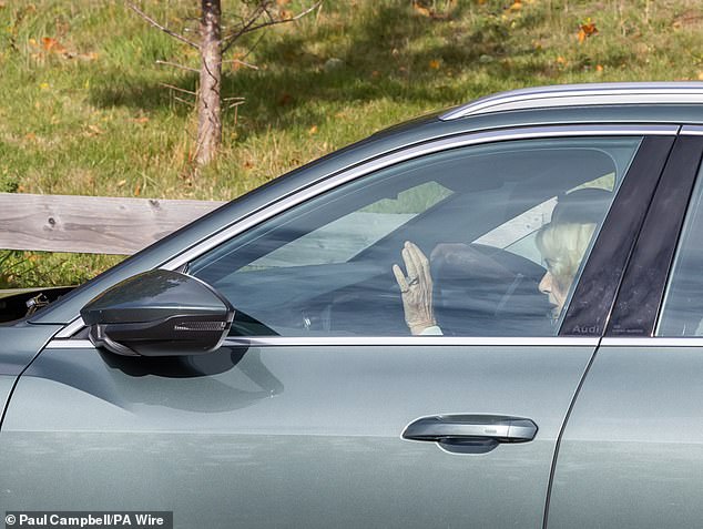 The Queen looked typically elegant in a green hat and a floral scarf draped around her shoulders