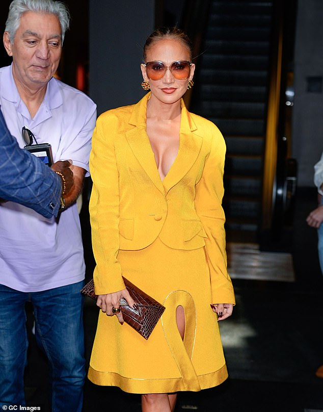 She accessorized with sunglasses and a brown leather clutch