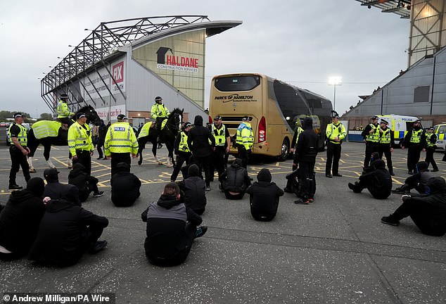 Pictured: Supporters performing a sit-down protest stopping the Rangers bus from leaving The Falkirk Stadium on Sunday