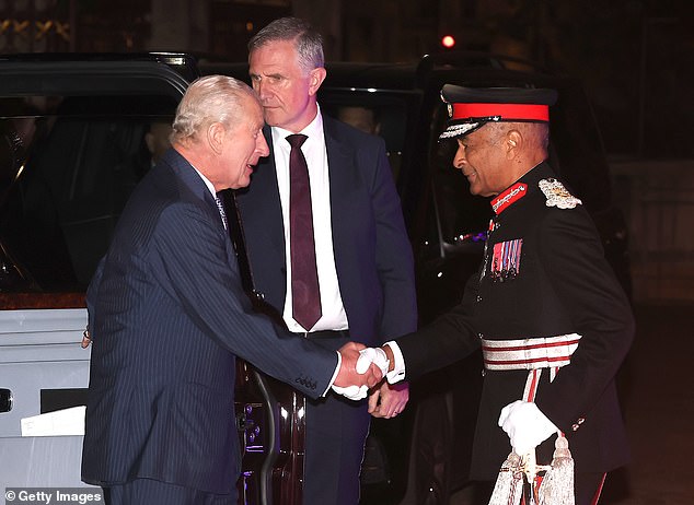 King Charles shaking the hand of a military personnel at the event