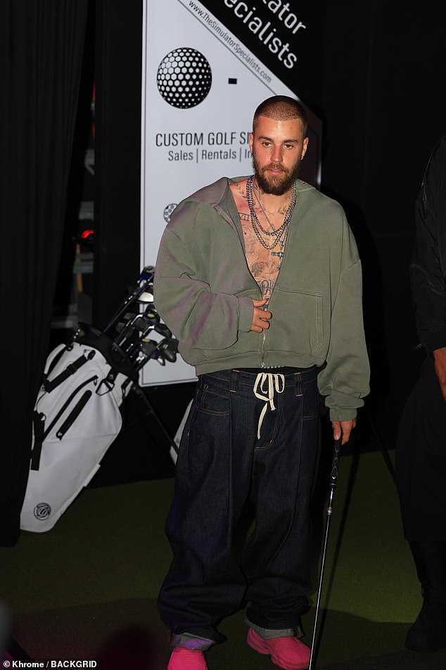 Justin showed off his tattoos under his green zip-up hoodie