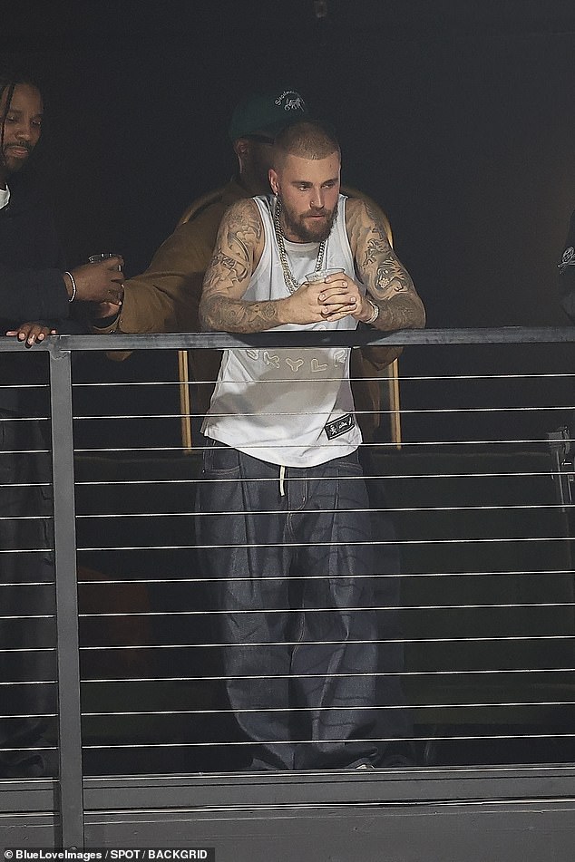He was seen with a drink in hand while leaning over a balcony