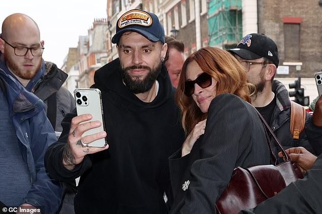 Julia happily chatted to some of them at the side of the pavement, and posed for selfies as she made her way to a waiting car
