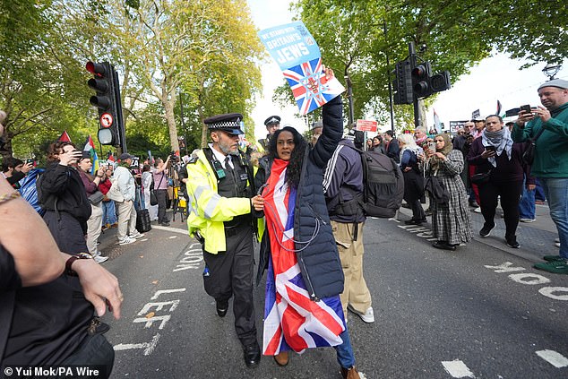 Officers from the Met Police were forced to intervene and escort multiple counter-protesters, holding signs that read 'We stand with British Jews' away from the scene