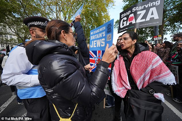 A Stop The Hate counter protest demonstrator speaks to a person taking part in a Palestine Solidarity Campaign march from Victoria Embankment to Downing Street