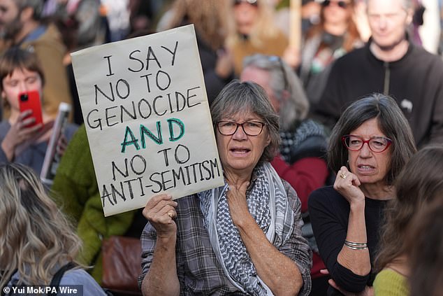 A woman holds a sign that reads: 'I say no to genocide and no to anti-Semitism' as she joins pro-Palestine protesters