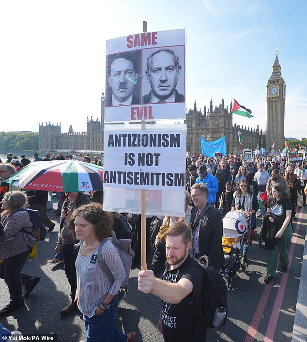 A sign held by a protester depicts Israeli Prime Minister Benjamin Netanyahu next to a picture of Adolf Hitler with the caption: 'Same evil'