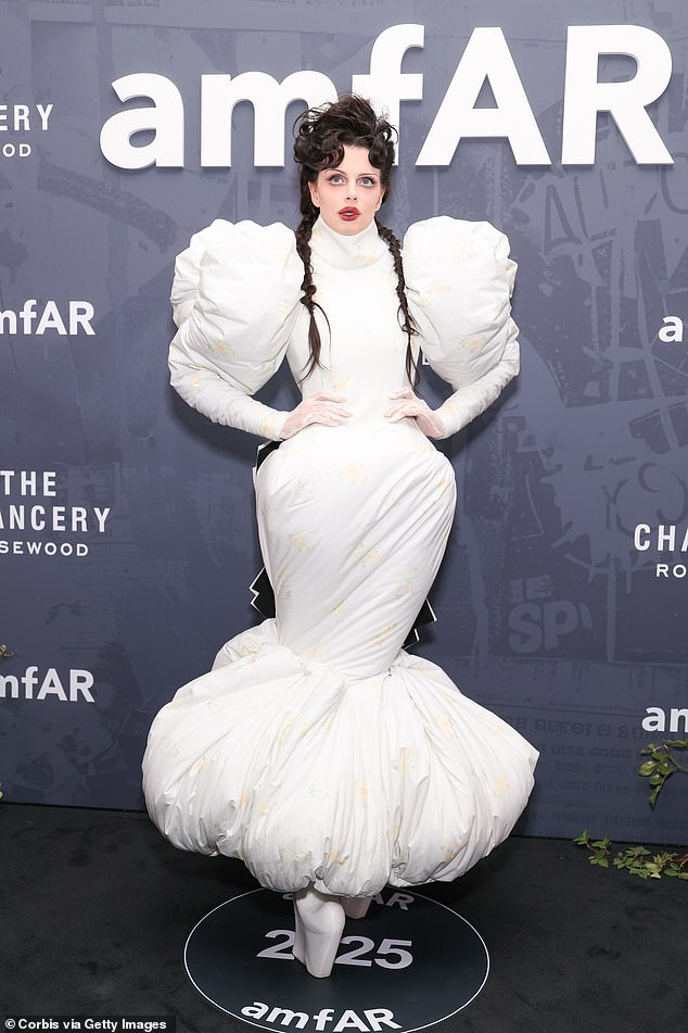 Julia Fox shows off her quirky style in a dramatic puff sleeve gown as she attended the amfAR gala in London on Friday