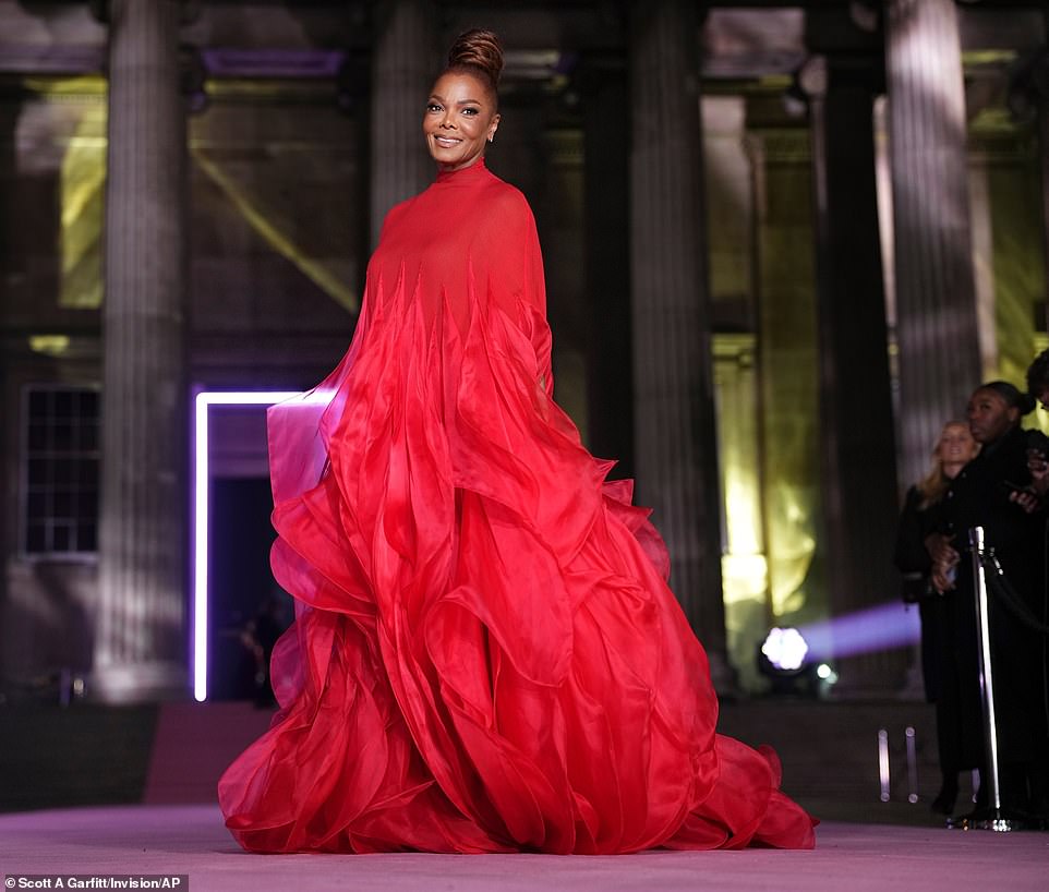 Janet's dress was complete with a high neckline and cascading layers of chiffon ruffles forming a cape effect, completely hiding her arms