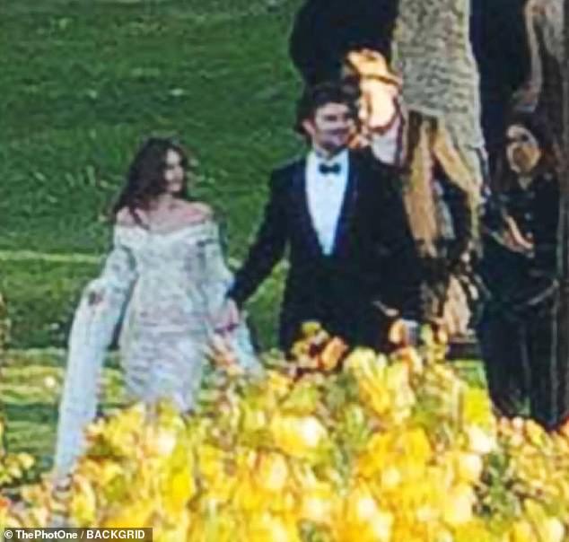 Photos show Stella and Alex walking hand-in-hand during the wedding, with the bride donning a stunning off-the-shoulder white wedding dress with dramatic, long sleeves