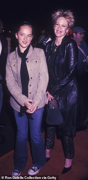 'When I was little, there were times when it was really quite scary, and people would aggressively and physically try to get to my mom when we were just going to the supermarket or something,' she said of her parents' celebrity; Johnson and mom Melanie Griffith seen in 2003