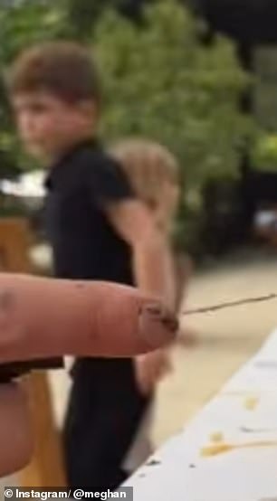 Archie (left) appeared to be wearing a smart black polo shirt and matching trousers