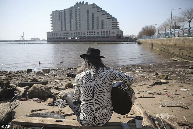 The Delaware River is used by Philadelphians and residents of Camden, New Jersey for drinking water and recreational activities. (Pictured: A man playing guitar on the shore of the Delaware River)