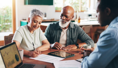 Retired couple with financial advisor planning for retirement fund