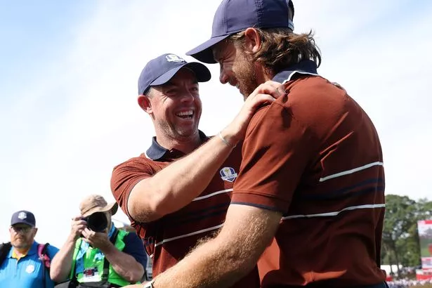 (L-R) Rory McIlroy and Tommy Fleetwood of Team Europe react after defeating Harris English and Collin Morikawa (not pictured) of Team United States 3&2 during the Saturday morning foursomes matches of the 2025 Ryder Cup at Black Course