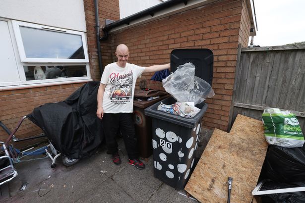 Michael Farrell with the bins in his yard at home in Litherland