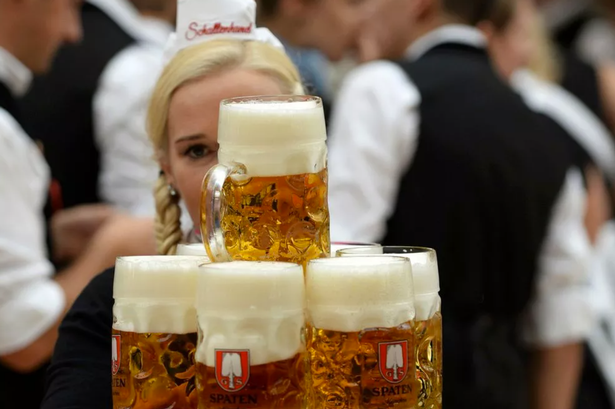 A waitress carries mugs of beer 