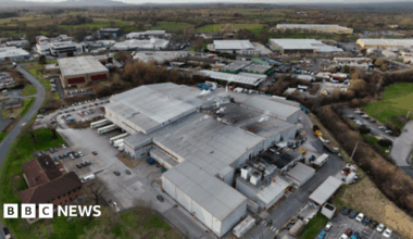 Sana el-Azab is sitting on a wall circling Durham Cathedral. She is smiling and is doing a peace sign with her hands.