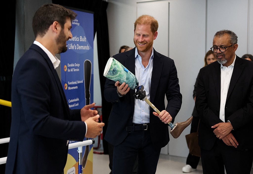 A person holds a prosthetic leg as they speak with other people.