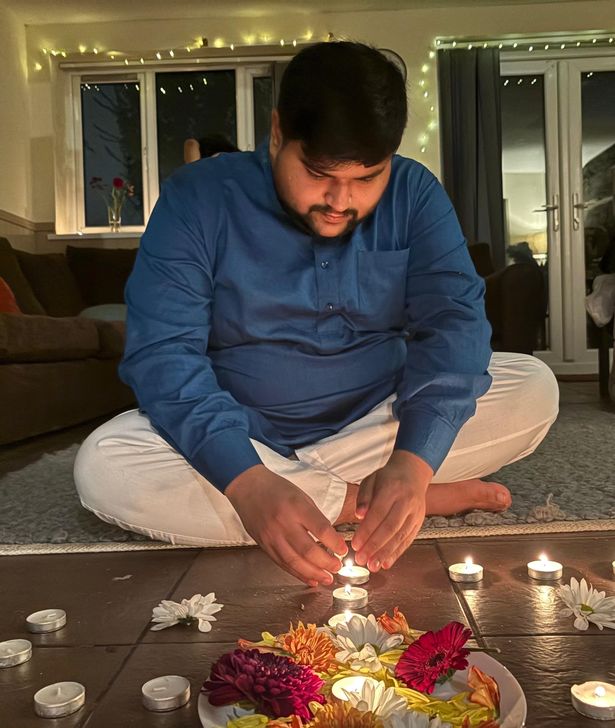 Shaurya lighting a candle while sitting on the floor