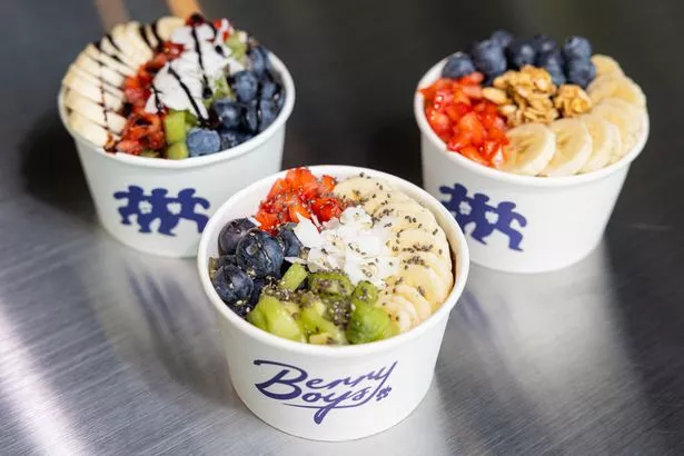 Açaí bowls brimming with the frozen açaí (a type of berry from the Amazon rainforest), sliced bananas, coconut flakes, but butter and homemade granola