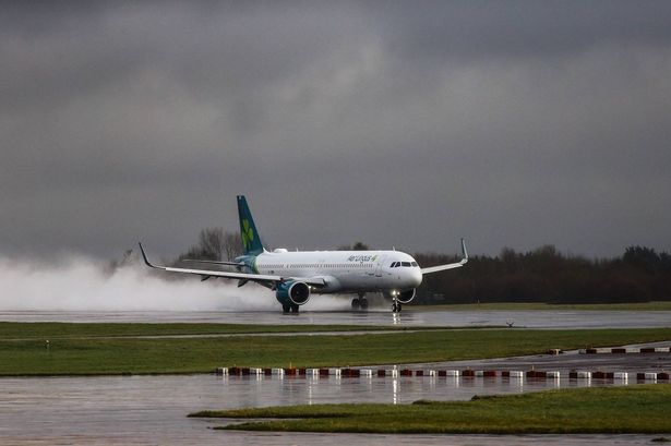 An Aer Lingus flight kicks up spray as it lands at Manchester Airport on Friday afternoon.