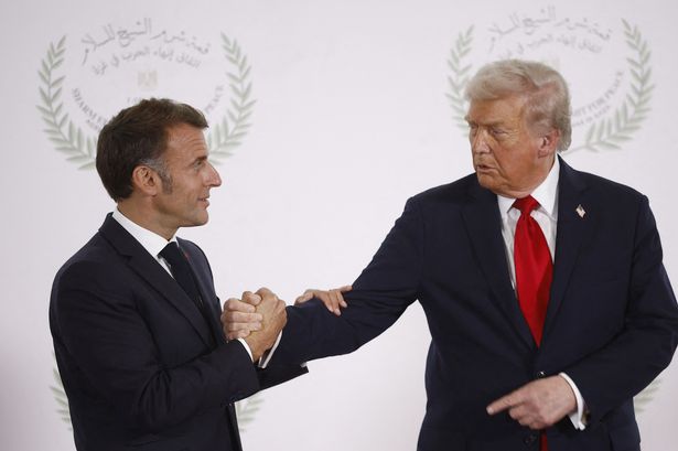 Emmanuel Macron shakes hands with Donald Trump