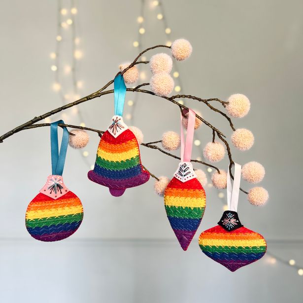 Designs include the Pride Progress flag and the raised fist of solidarity – symbols that reflect the stories and values championed by PHM – together with timeless festive motifs