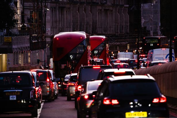 Cars and buses queue in a long traffic jam on Knightsbridge in London, England