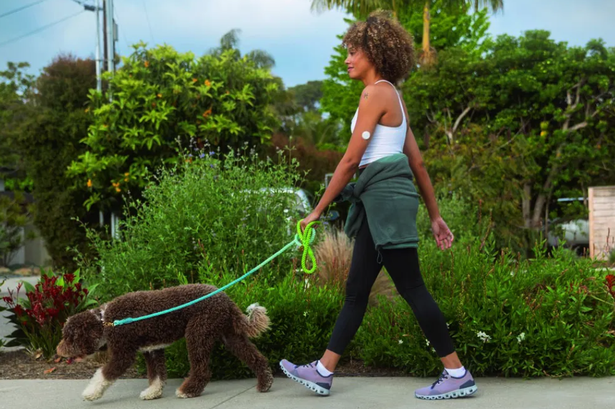 Woman walking her dog while wearing Lingo biosensor