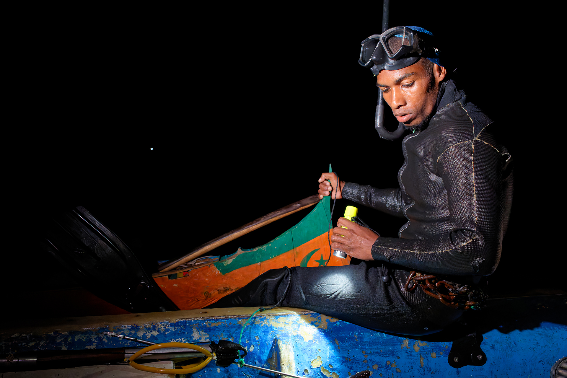 A diver flashing his light on hte eel he just caught