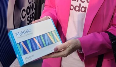 MyRisk genetic screening kit being held by a person wearing a pink jacket