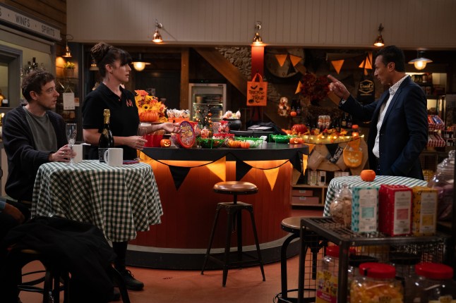 Jai talks to Kerry and Matty across the shop in Emmerdale