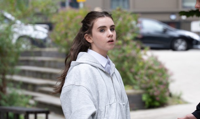 April standing in a grey jacket looking worried in Emmerdale