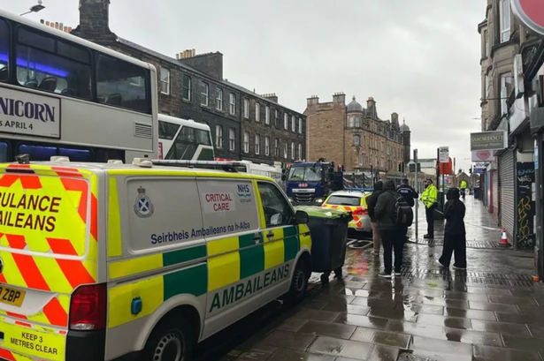 A critical care unit and police officers begind a taped off area of London Road.