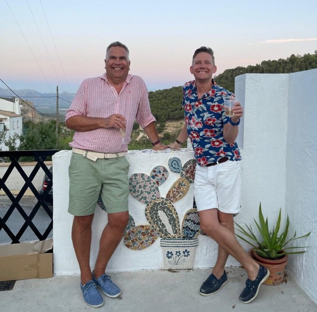 Ian Rutter and Andrew Watson leaning against their balcony in Moclin, Granada, Spain