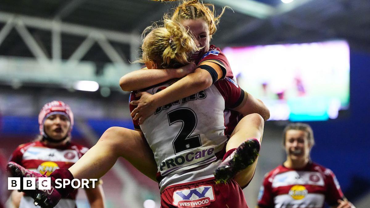 Wigan warriors winger Anna Davies is hugged by teammate Grace Banks after scoring a try in the Grand Final against St Helens.