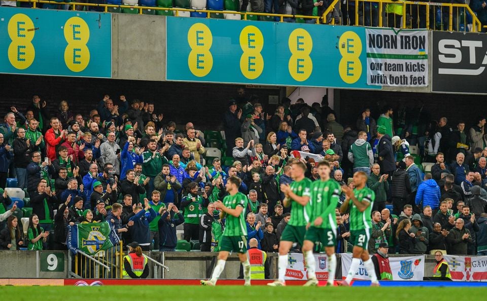 Northern Ireland fans in the lower deck of the North Stand applaud the players