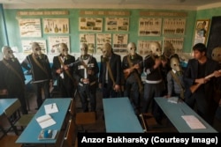 School children trying on gas masks in Bukhara.