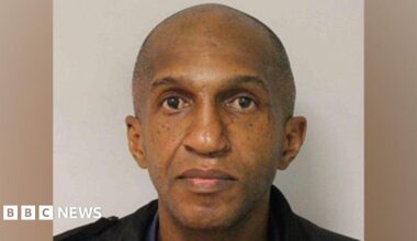 Anthony Marks wearing a dark shirt and jacket, looking directly into the camera