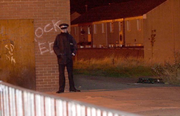 Police stand guard at the crime scene where Tony Lawlor was shot dead 