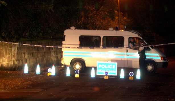 Police at the scene where a burned out van was found believed to have been the one used by gunmen when they shot and killed Tony Lawlor