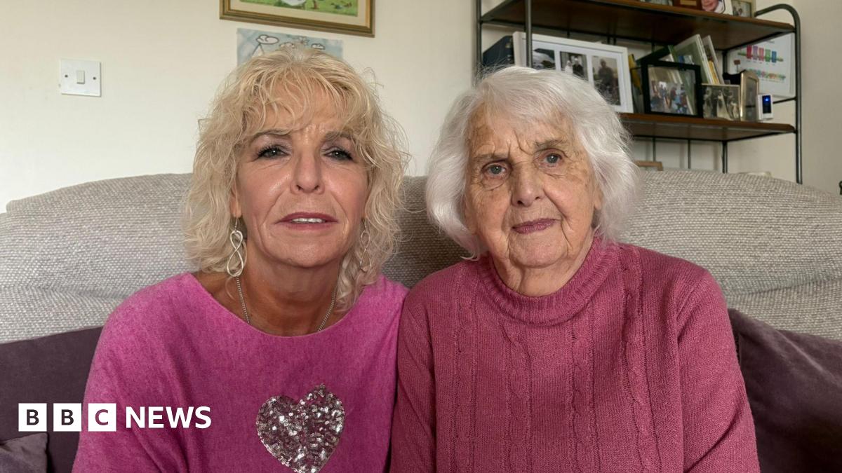 Judith Bosustow sitting on the left with blond hair in a pink jumper, beside her mum, Joan, in a purple jumper with white hair