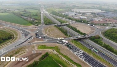 The M4 with multiple lanes of traffic and buildings and fields either side