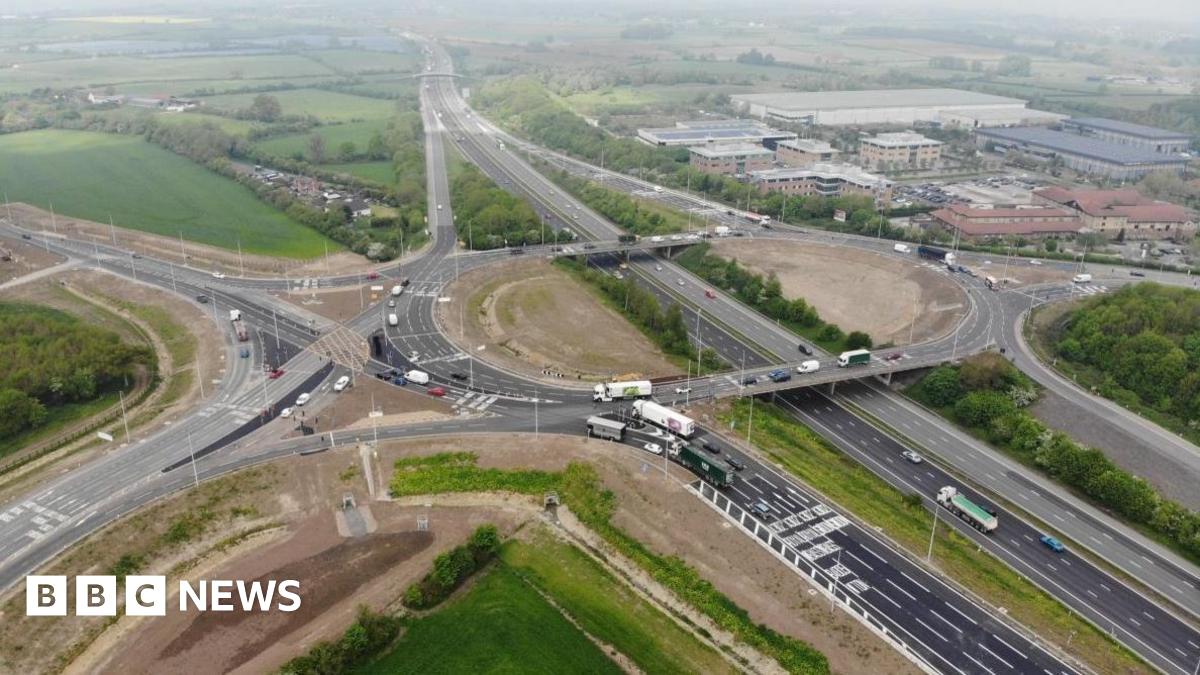 The M4 with multiple lanes of traffic and buildings and fields either side