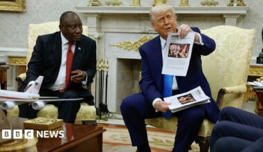 President Trump holding up papers with images during next to President Ramaphosa.