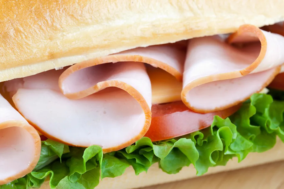Close up of clean freshly made sandwich with meat, lettuce, tomato and cheese
