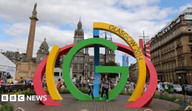 Visitors  climb on the Big G sculpture in George Square, Glasgow ahead of the Commonwealth Games 2014