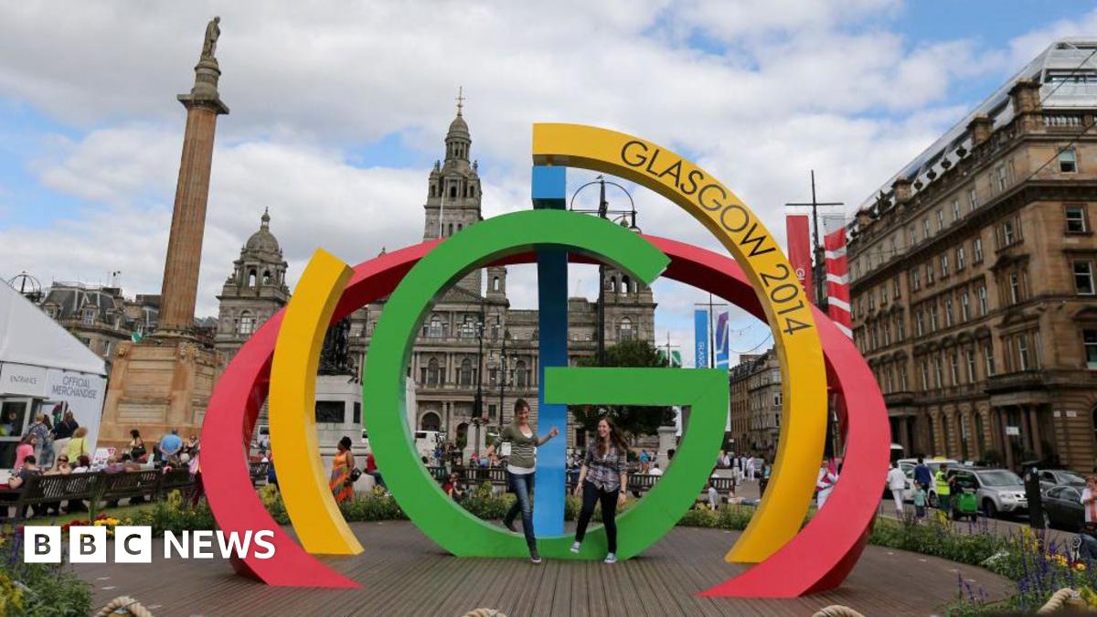 Visitors  climb on the Big G sculpture in George Square, Glasgow ahead of the Commonwealth Games 2014